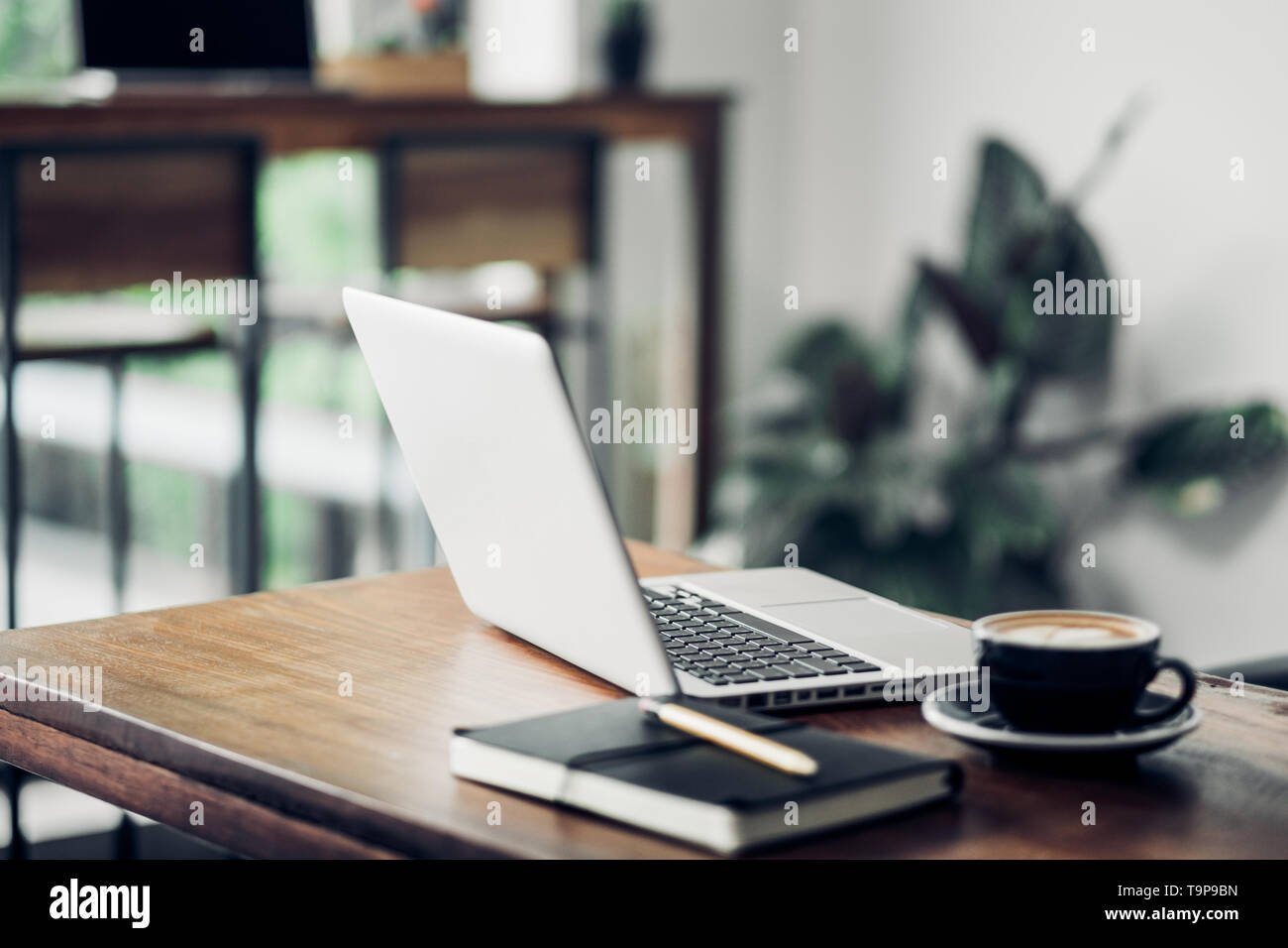 Laptop on wood table and coffee cup and notebook in cafe restaurant ...