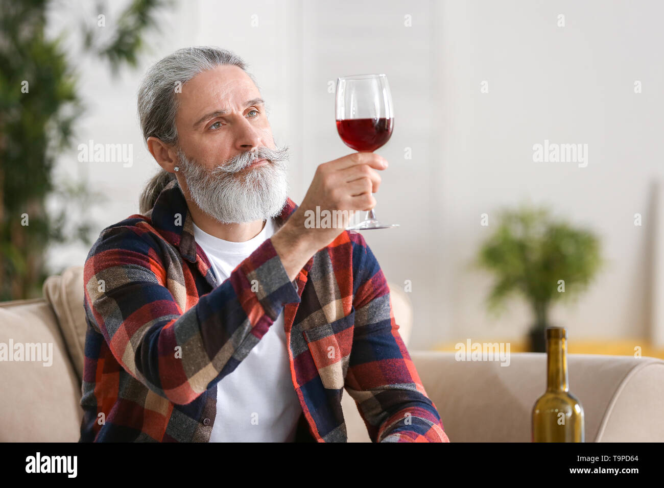 Senior man drinking wine at home Stock Photo - Alamy