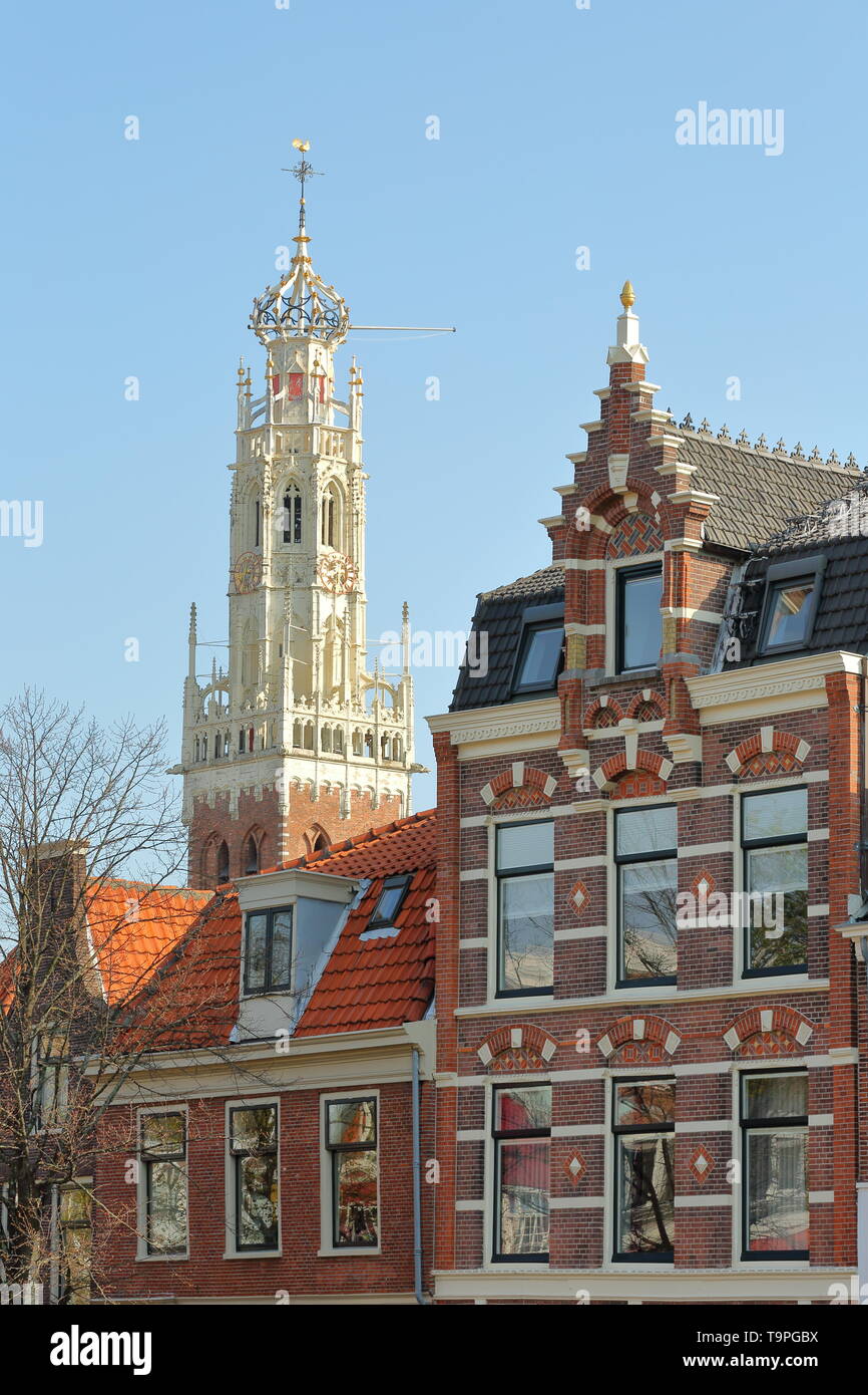 Close-up on traditional and colorful facades located along Spaarne river, with the white tower of Bakenesserkerk church, Haarlem, Netherlands Stock Photo