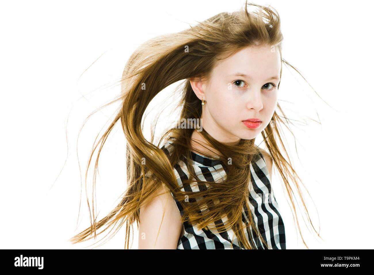 Young Girl With Long Straight Hairs Blown By Wind In Studio Hair