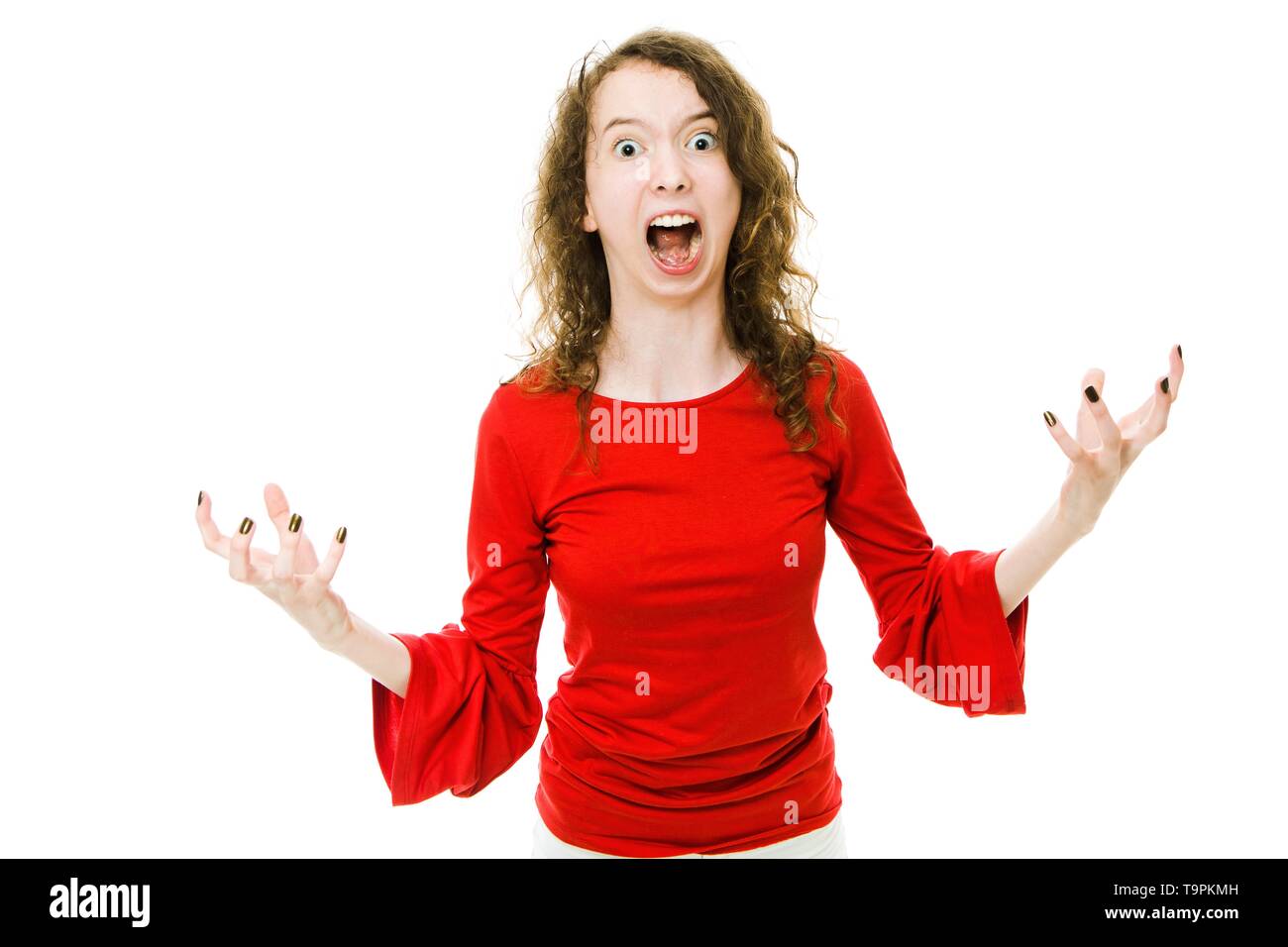 Shouting girl in red dress showing gesture of aggressive behavior expression of rage Stock
