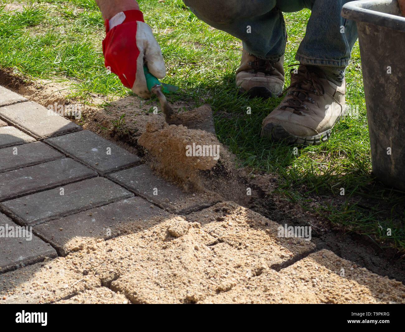 Laying gray concrete paving slabs in house courtyard driveway patio