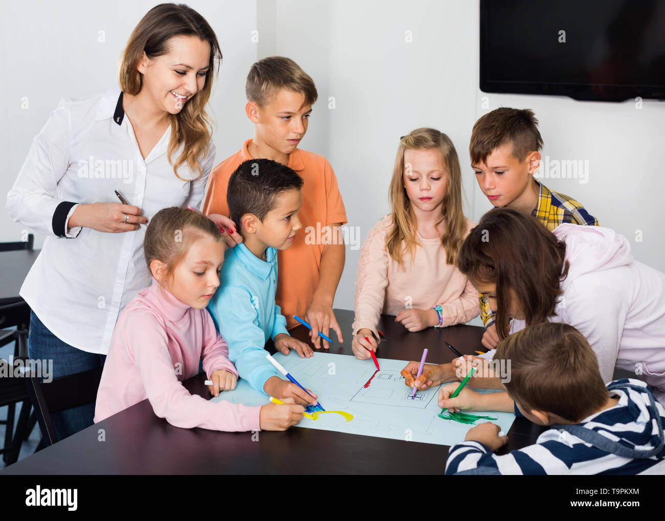Little happy smiling children with teacher drawing together in ...