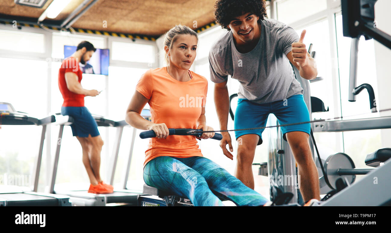 Young beautiful woman doing exercises with personal trainer Stock Photo