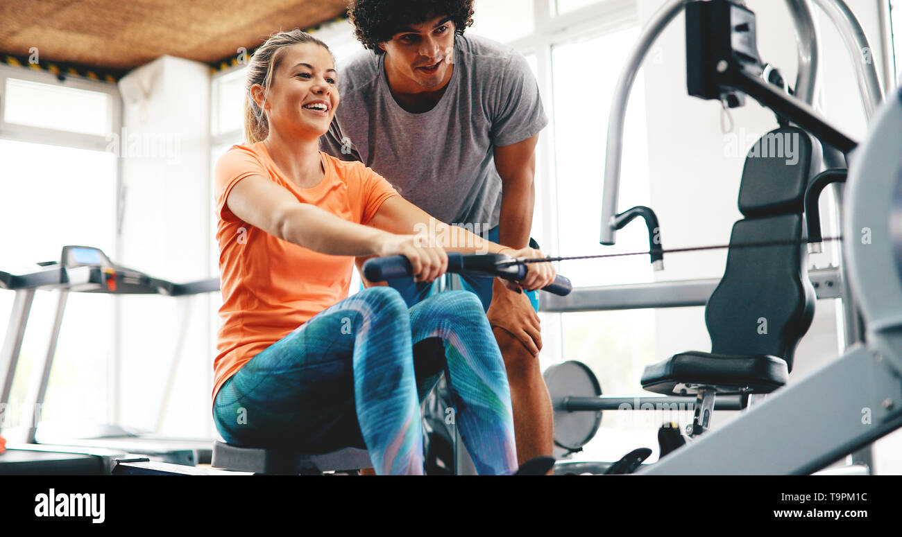 Young beautiful woman doing exercises with personal trainer Stock Photo