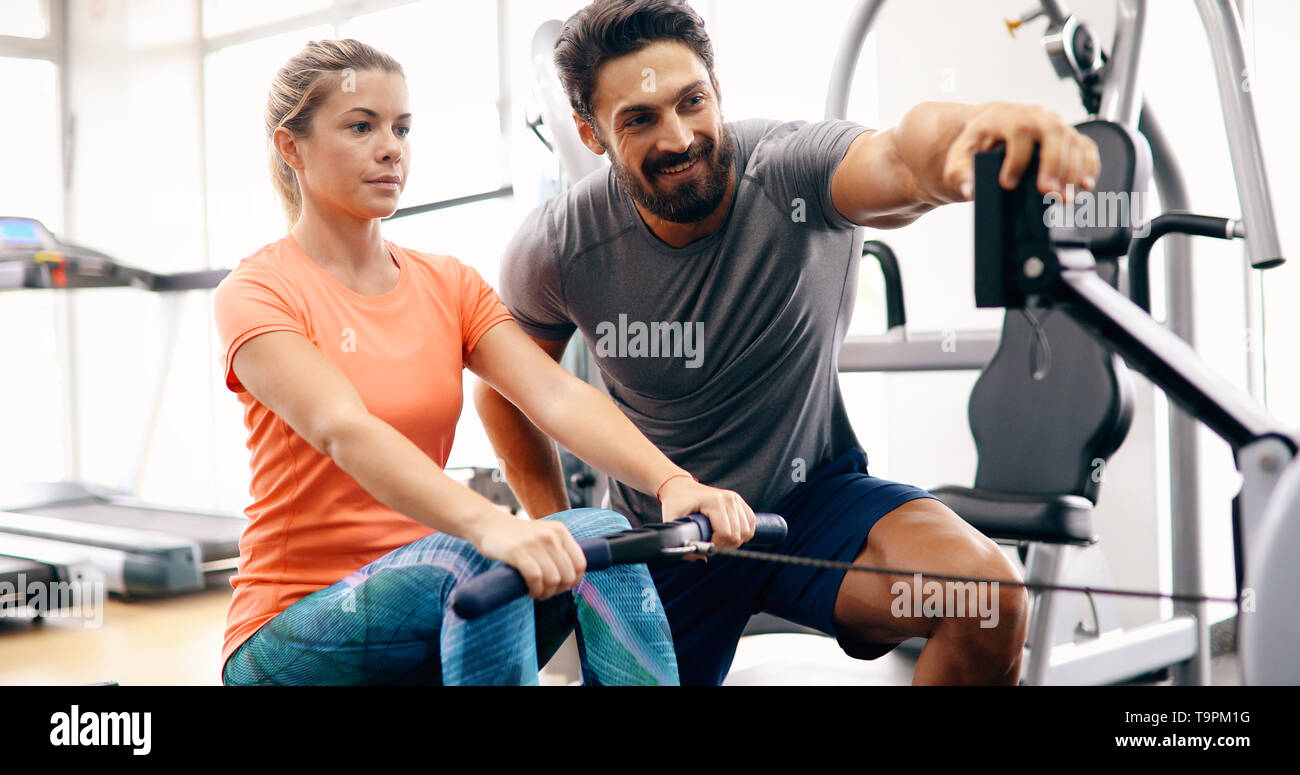 Young beautiful woman doing exercises with personal trainer Stock Photo