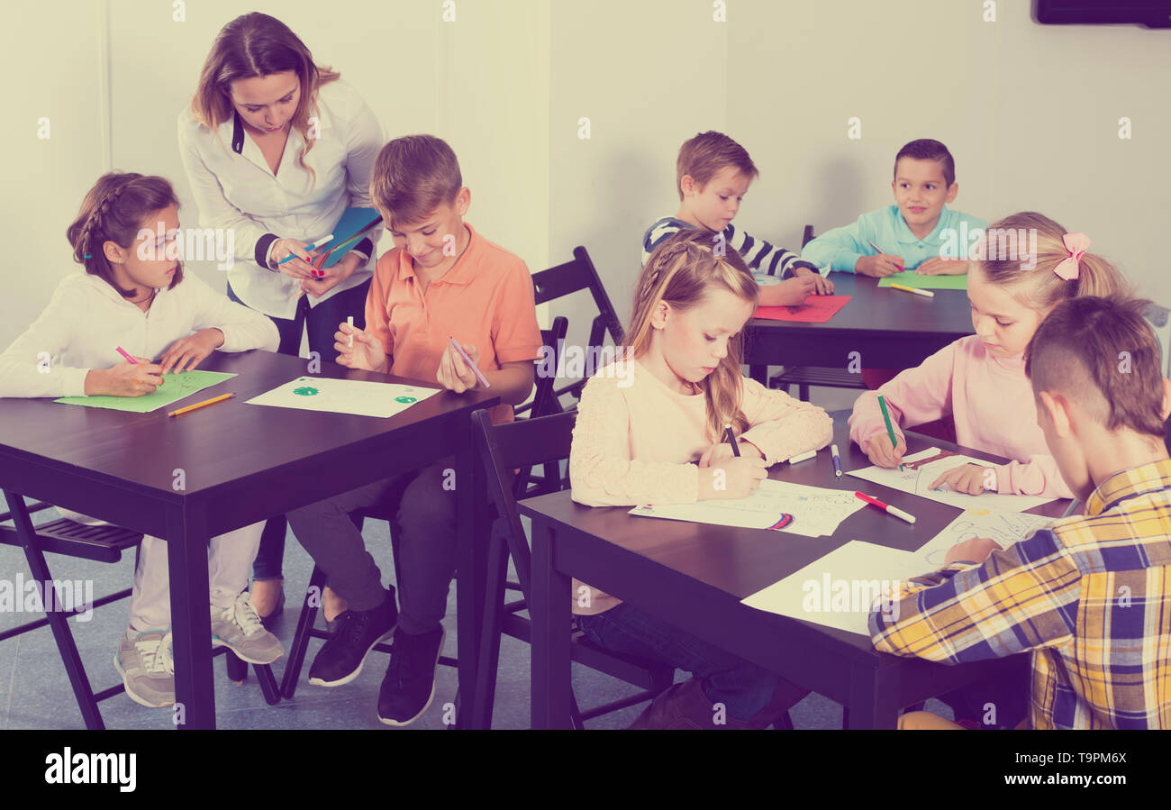 Group of children in elementary age drawing together at classroom Stock ...