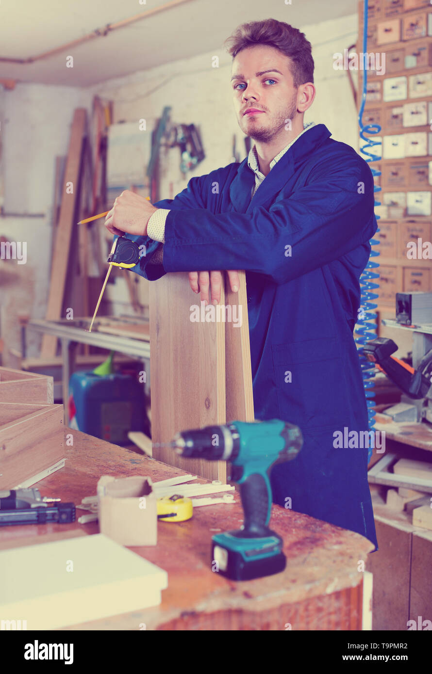 Efficient working man measuring boards for furniture at Stock
