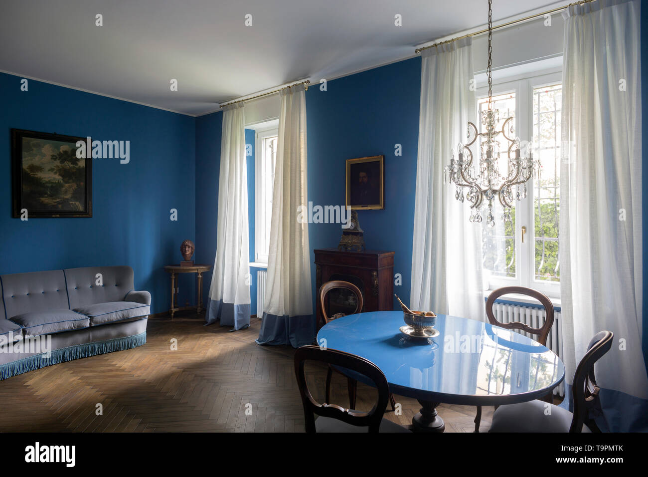 Elegant living room in a private apartment in Milan with blue walls, Italy. Stock Photo