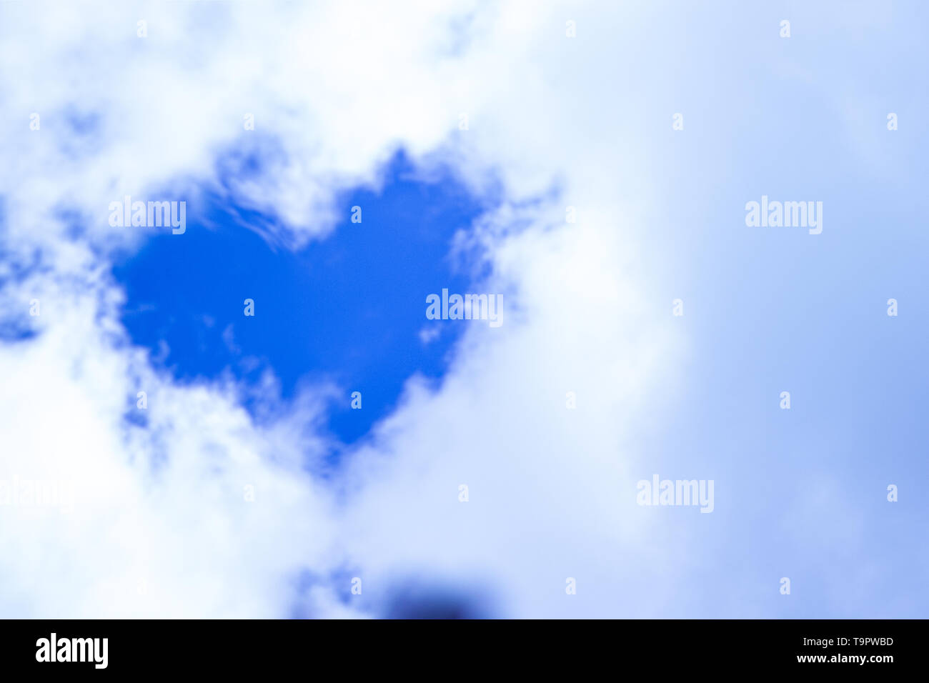 a blue sky with clouds and the shape of a heart Stock Photo - Alamy
