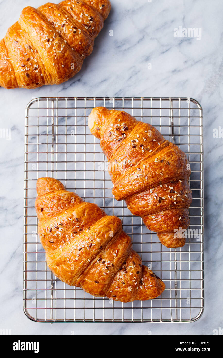 Croissants on cooling rack. Traditional French food. Marble background