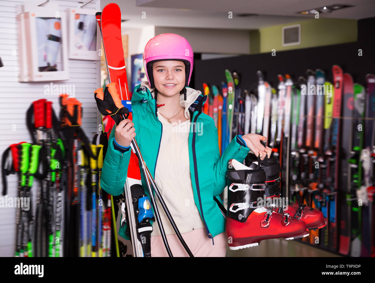 Pretty girl in skiing outfit satisfied with choice in modern store of