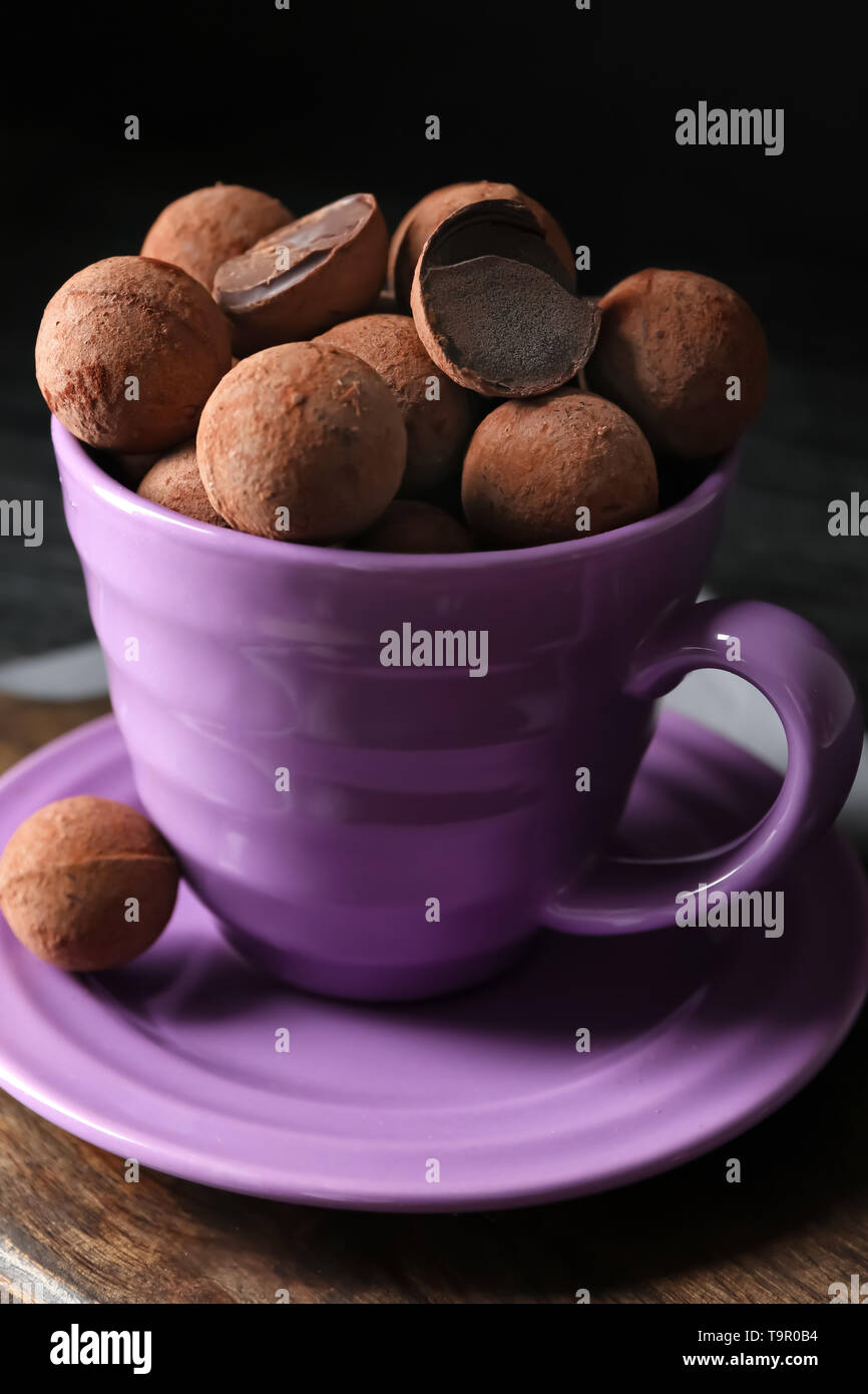 Cup with sweet truffles on table Stock Photo