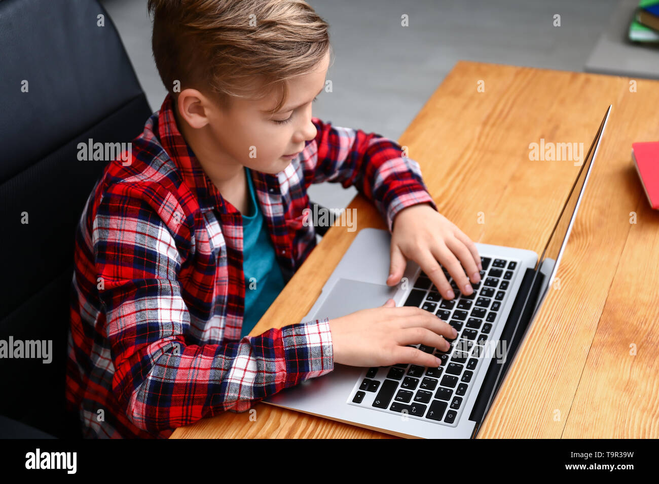 Cute boy playing video game on laptop at home Stock Photo - Alamy
