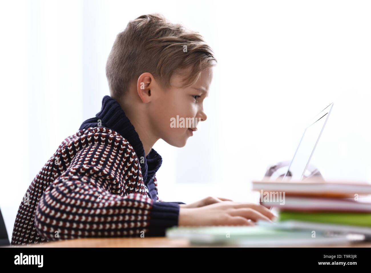 Cute boy playing video game on laptop at home Stock Photo - Alamy