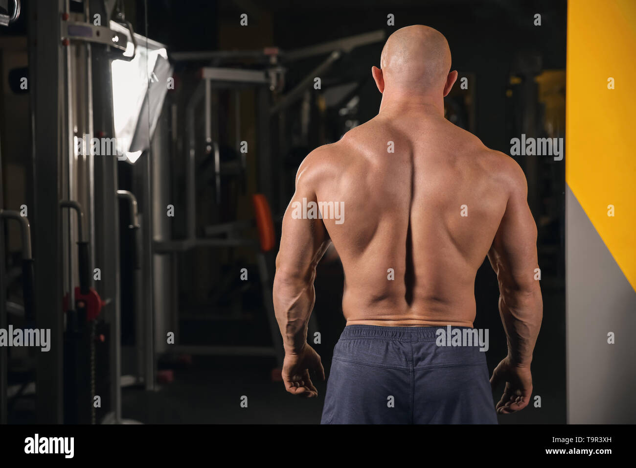 Muscular man standing near mirror in gym Stock Photo Alamy