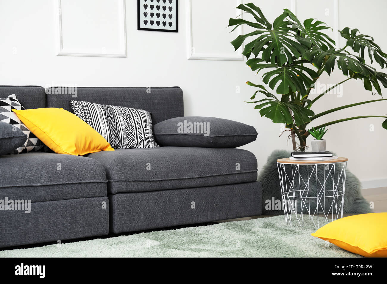 Stylish interior of living room with comfortable grey sofa Stock Photo ...