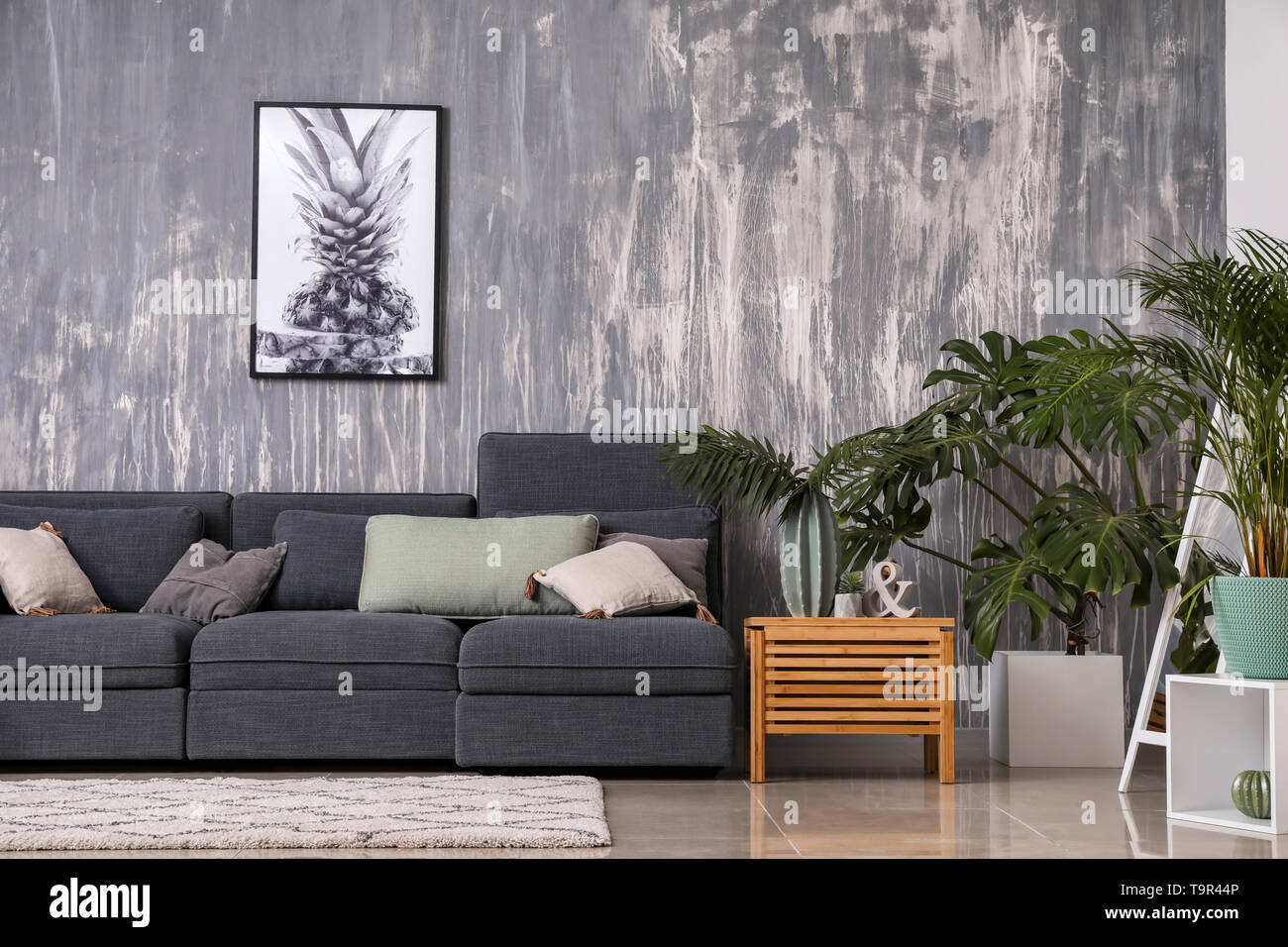 Stylish interior of living room with comfortable grey sofa Stock Photo ...