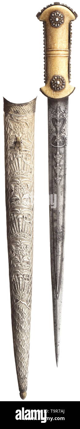 A silver-mounted Ottoman spearhead dagger, 1st half of 19th century Double-edged blade of wootz Damascus with ridged point, both sides of the root ornamentally chiselled. The intact walrus grip panels with filigree grip strap and ornamental silver studs on both sides (grip strap with unilateral loss at the blade). Nickel silver scabbard chased on both sides with flowers and trophy bundles. Length 54 cm. historic, historical, Ottoman, Orient, Oriental, Asia, Asian, 19th century, Additional-Rights-Clearance-Info-Not-Available Stock Photo