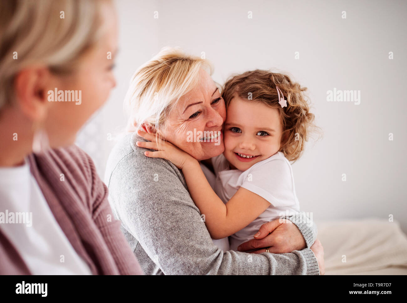 A portrait of small girl with mother and grandmother at home Stock ...