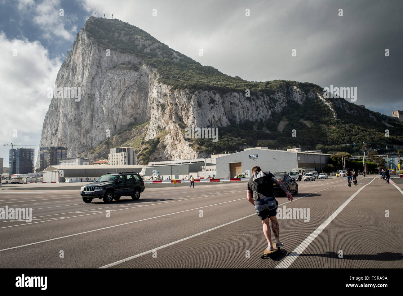 A man skates crossing  the asphalt at Gibraltar  international airport (British overseas territory)  near the border with Spain. Stock Photo