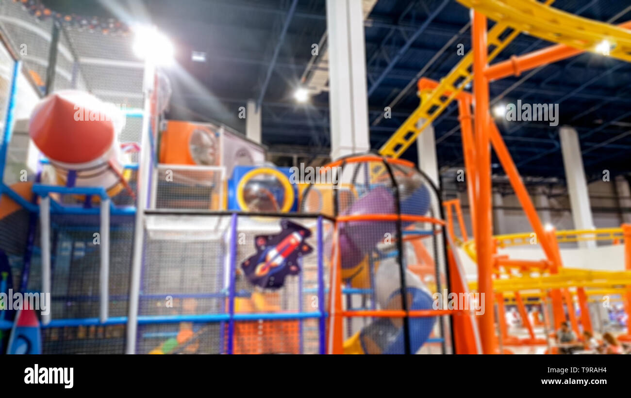 Blurred image of colroful children palyground and roller coaster in amusement park at shopping mall Stock Photo