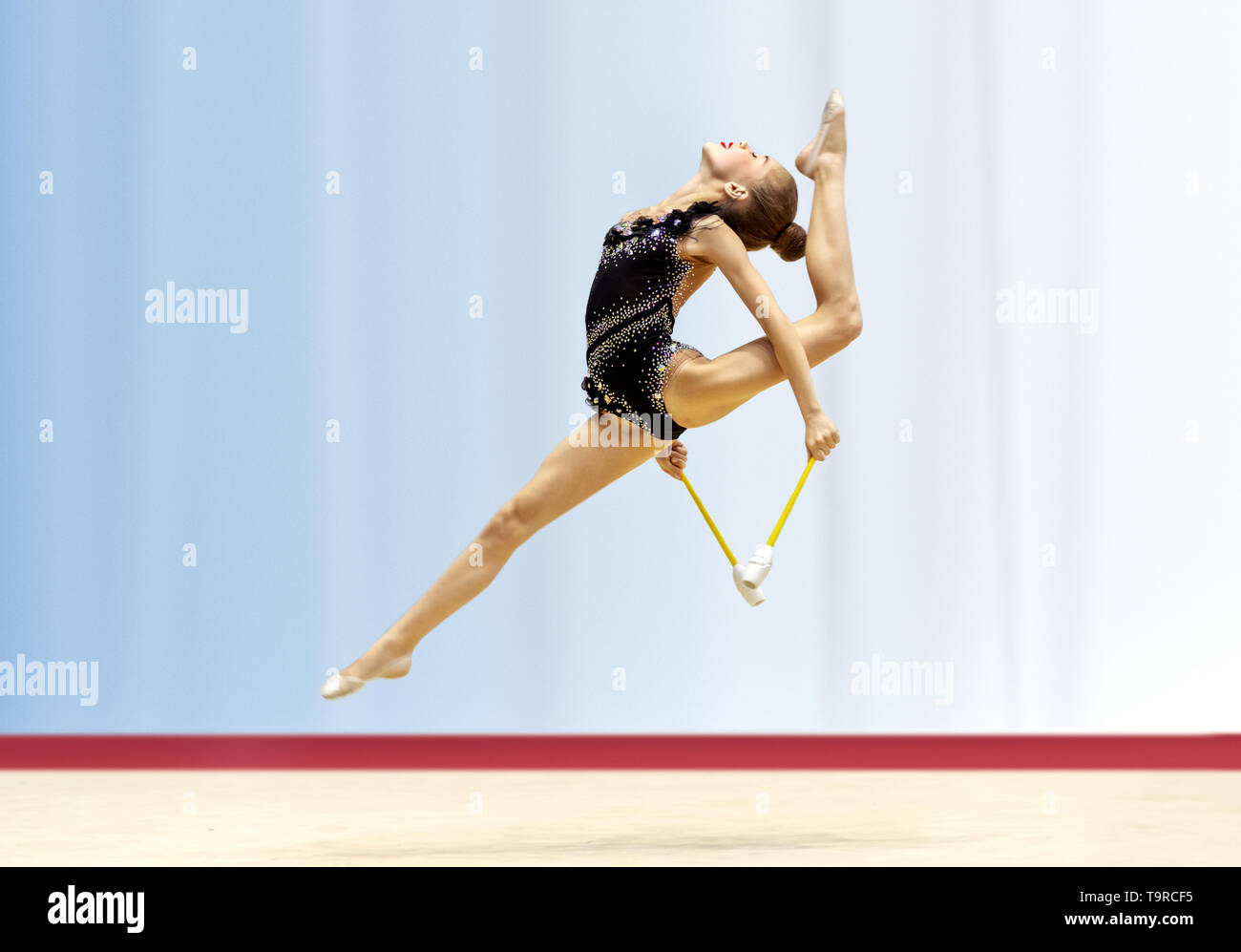 Delightful acrobatic jump with a splits performed by a young gymnast, a