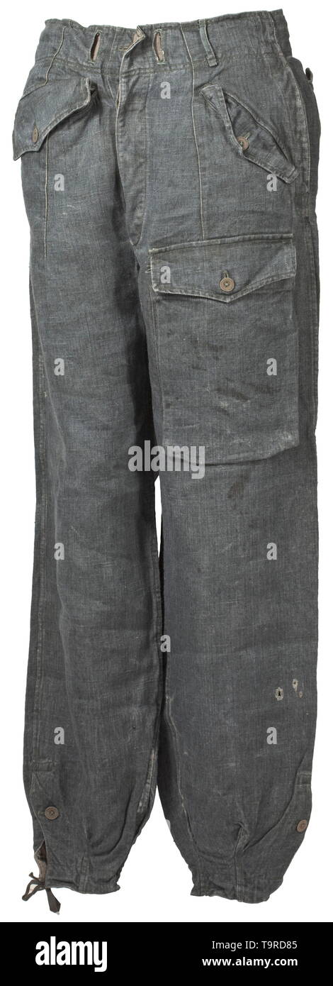A pair of trousers to the fatigue outfit for tank- or assault gun crews depot piece Broad-cut trousers of field-grey drill cloth with covered fly and sheet metal or cardboard buttons. The two front pockets of unequal sizes and integrated at different angles, superimposed pocket on the left upper thigh, integrated straight hip pockets, each with closure flap and a single button, leg closure with overfall. Brownish imitation silk liner. The web belt missing, signs of usage and small blemishes. A very rare special clothing issue. historic, historical, 20th century, Editorial-Use-Only Stock Photo