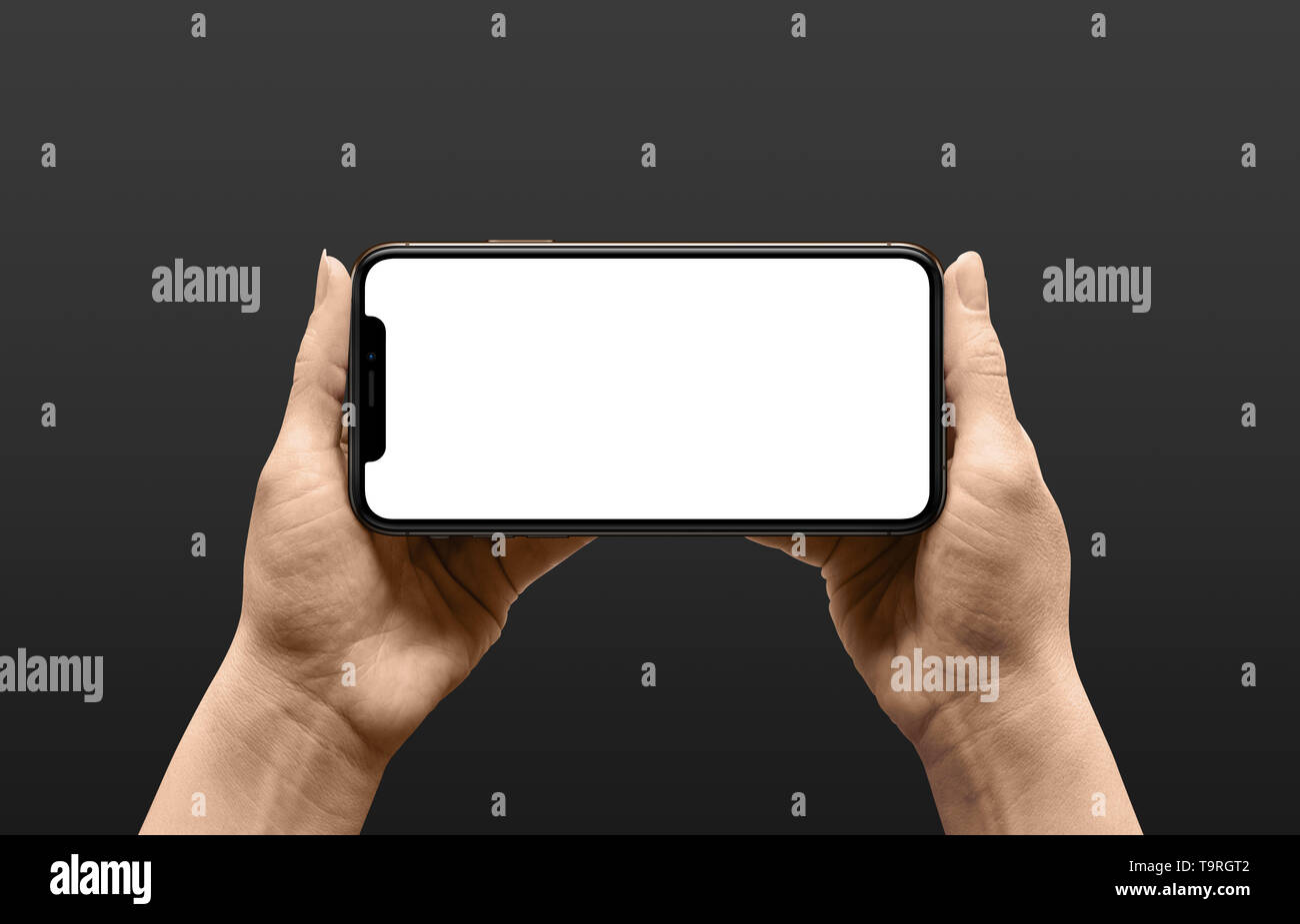 Modern smart phone with round, thin edges and under display camera in woman hands in horizontal position. Black background. Stock Photo