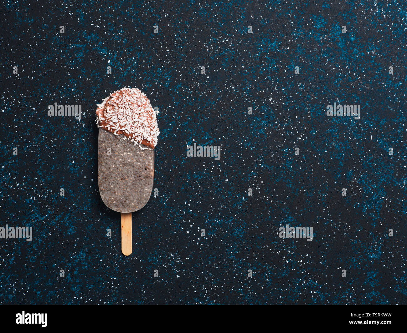 Chia popsicle with chocolate on dark blue background. Healthy recipe and idea homemade vegan popsicle ice cream. Easter dessert idea. Copy space for text. Top view or flat-lay. Stock Photo