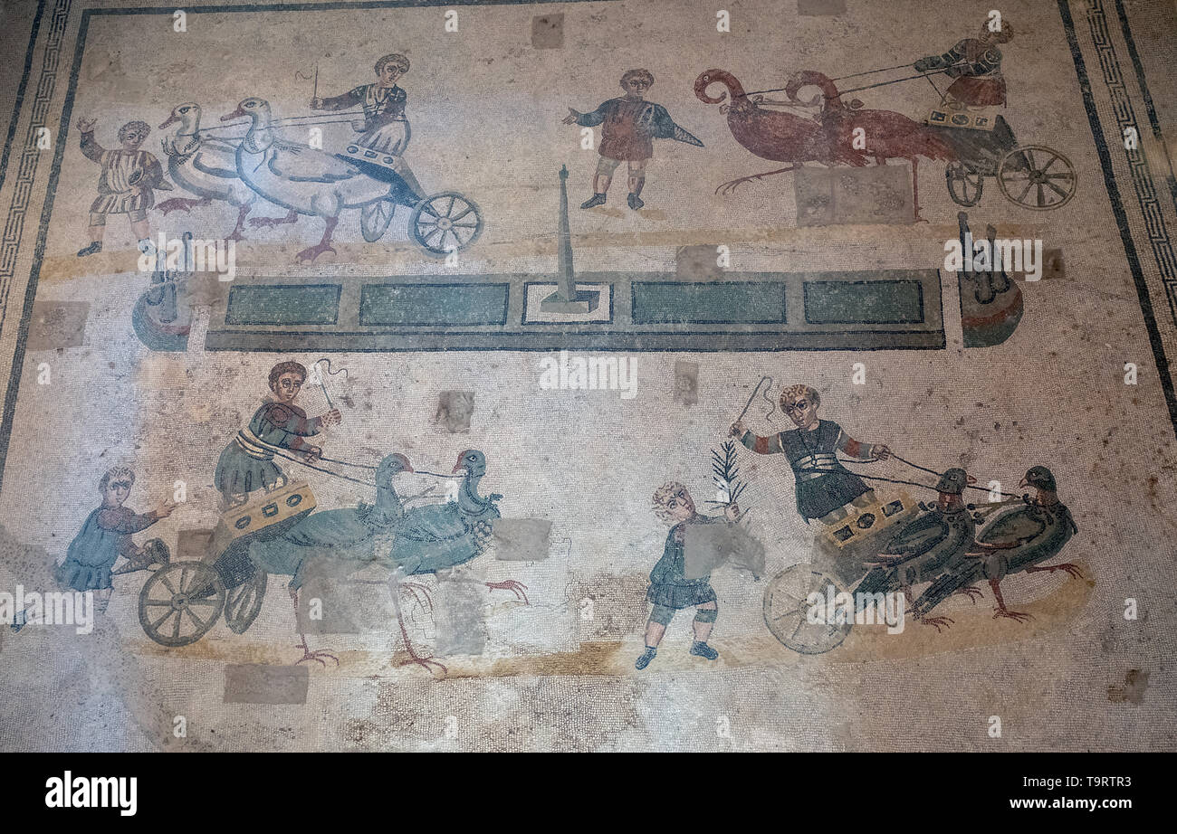 Children's chariot race one of the Roman mosaics in the Villa Romana del Casale, Piazza Armerina, Sicily, Italy. Stock Photo