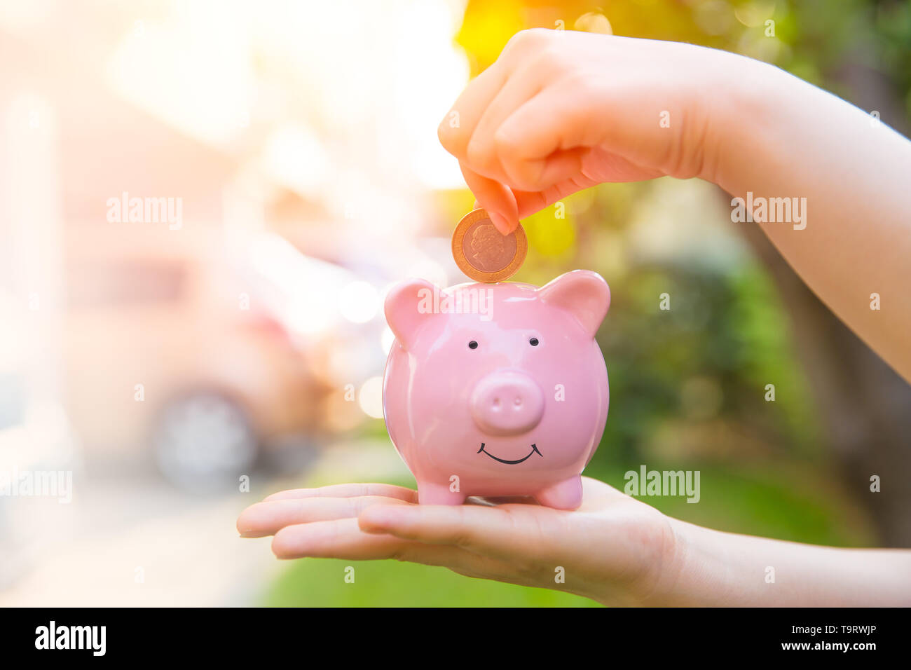 Piggy Bank with hand saving deposit coin money with copy space Stock Photo