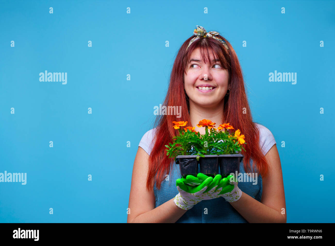 Photo of happy brunette at side with marigolds in her hands Stock Photo