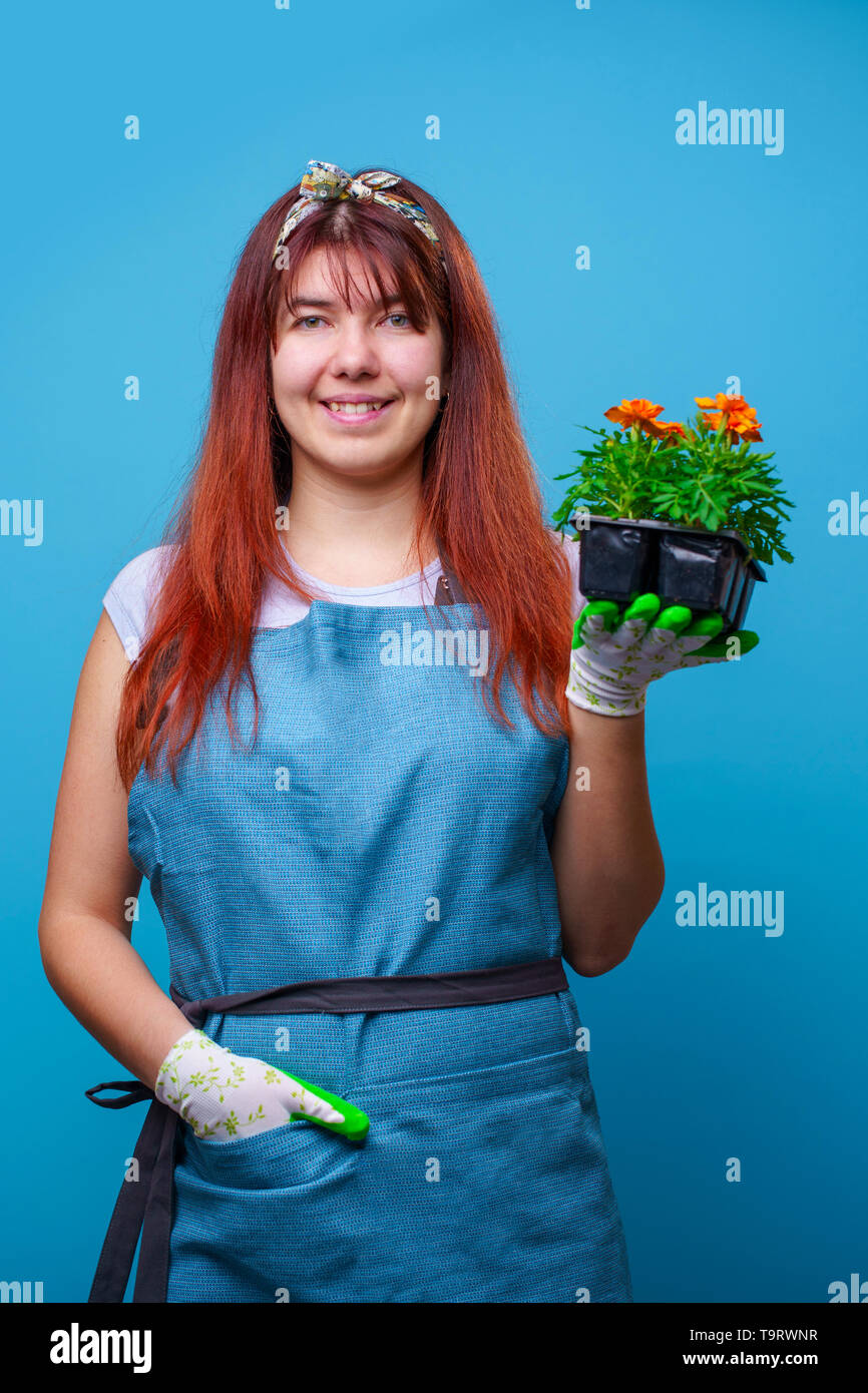 Photo of happy brunette girl with marigolds in her hands Stock Photo