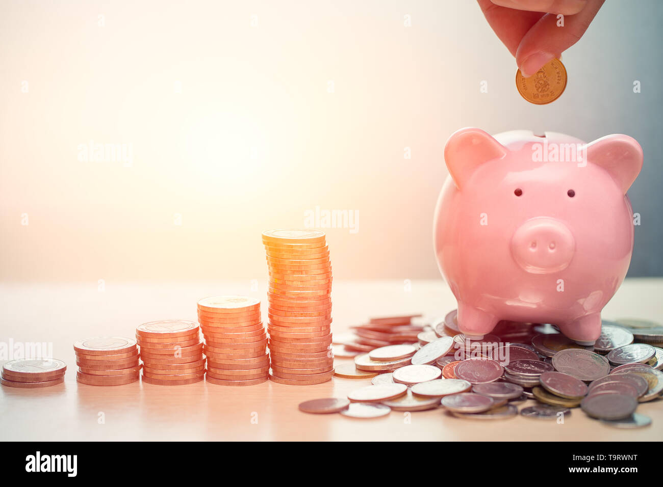 Hand Saving Money concept, Piggy bank with coin for Wealth Income and Profit Financial Business Grow Stock Photo