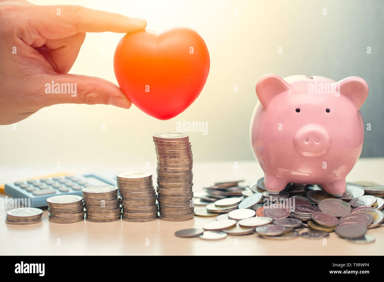 Love Heart and Saving Money Piggy Bank for Life insurance Share or Donation concept. Stock Photo