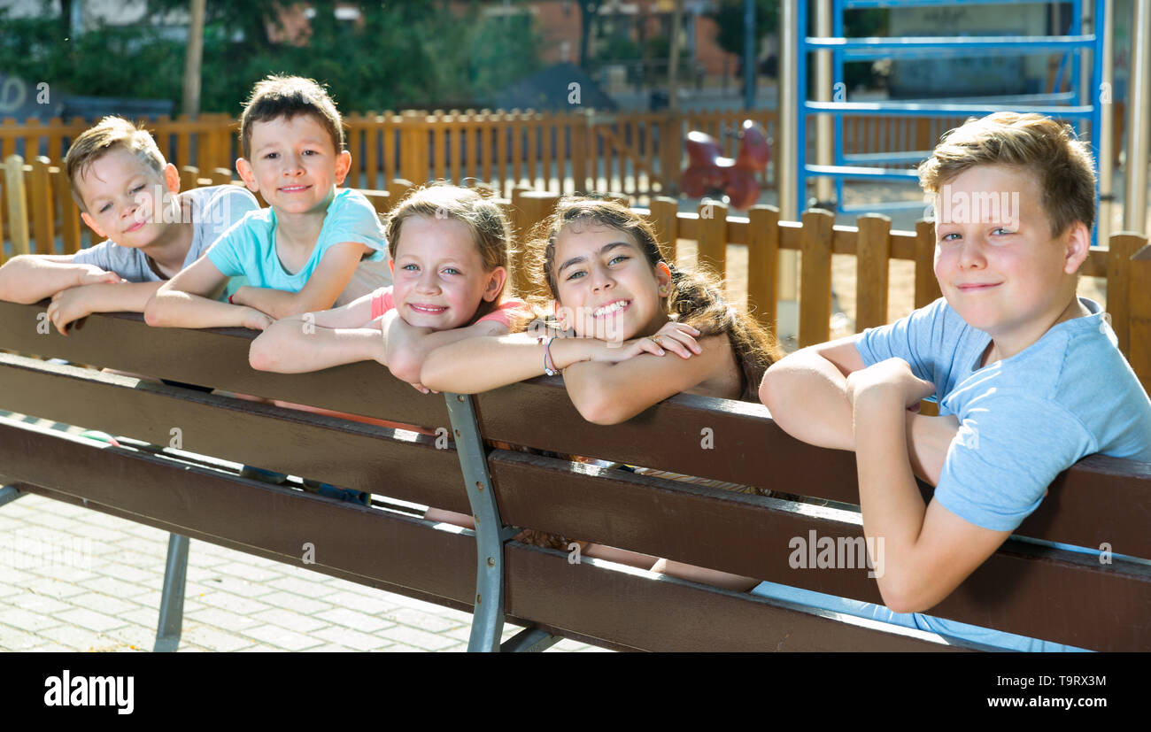 Five children sitting on the bench at the playground Stock Photo - Alamy