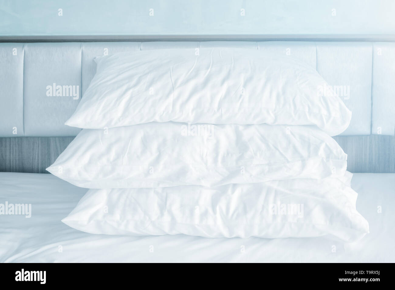comfortable soft pillows stack on the white bed sheets in modern bed room Stock Photo