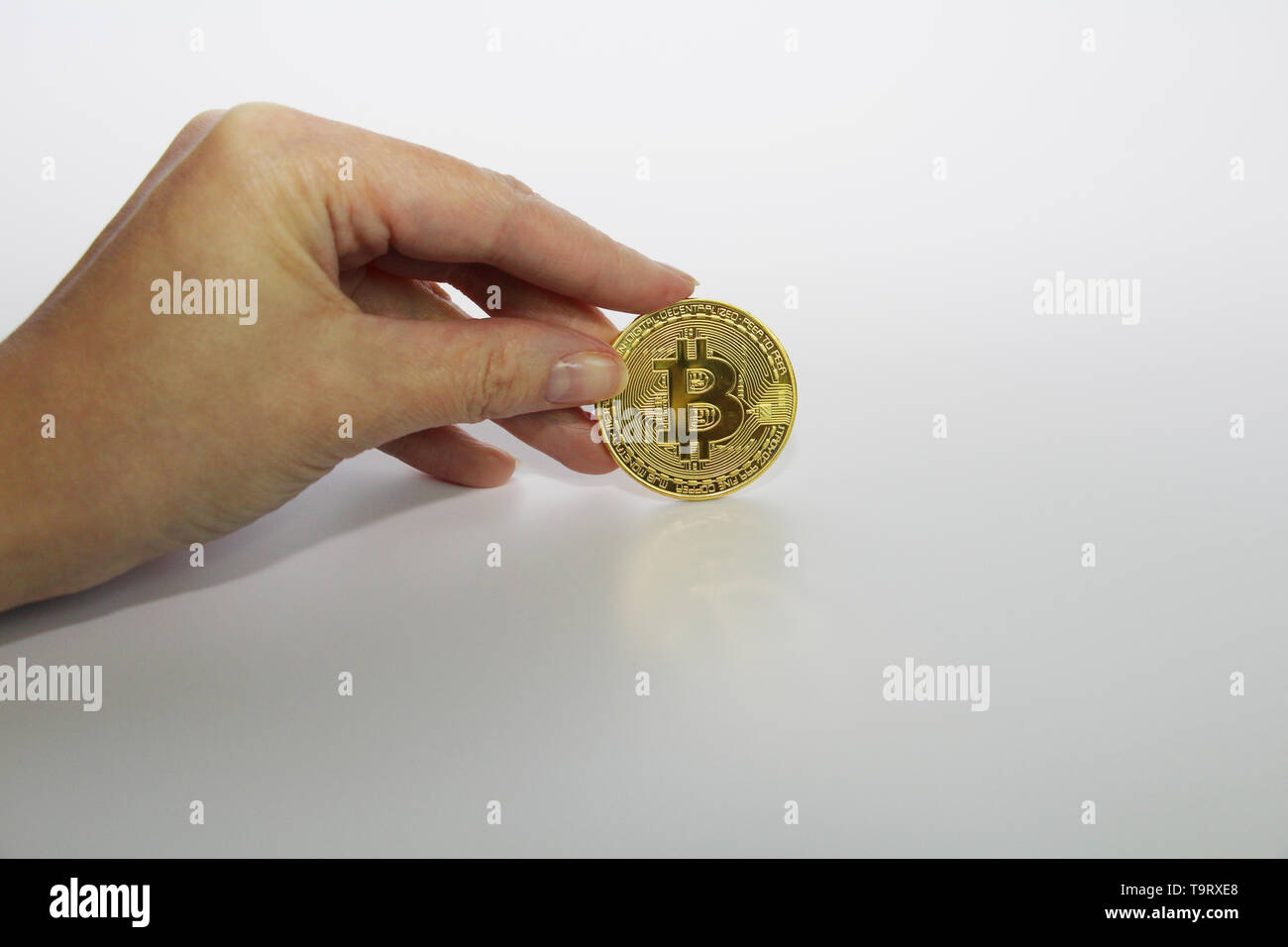 a finger holds a gold coin bitcoin on top of the pyramid Stock Photo - Alamy