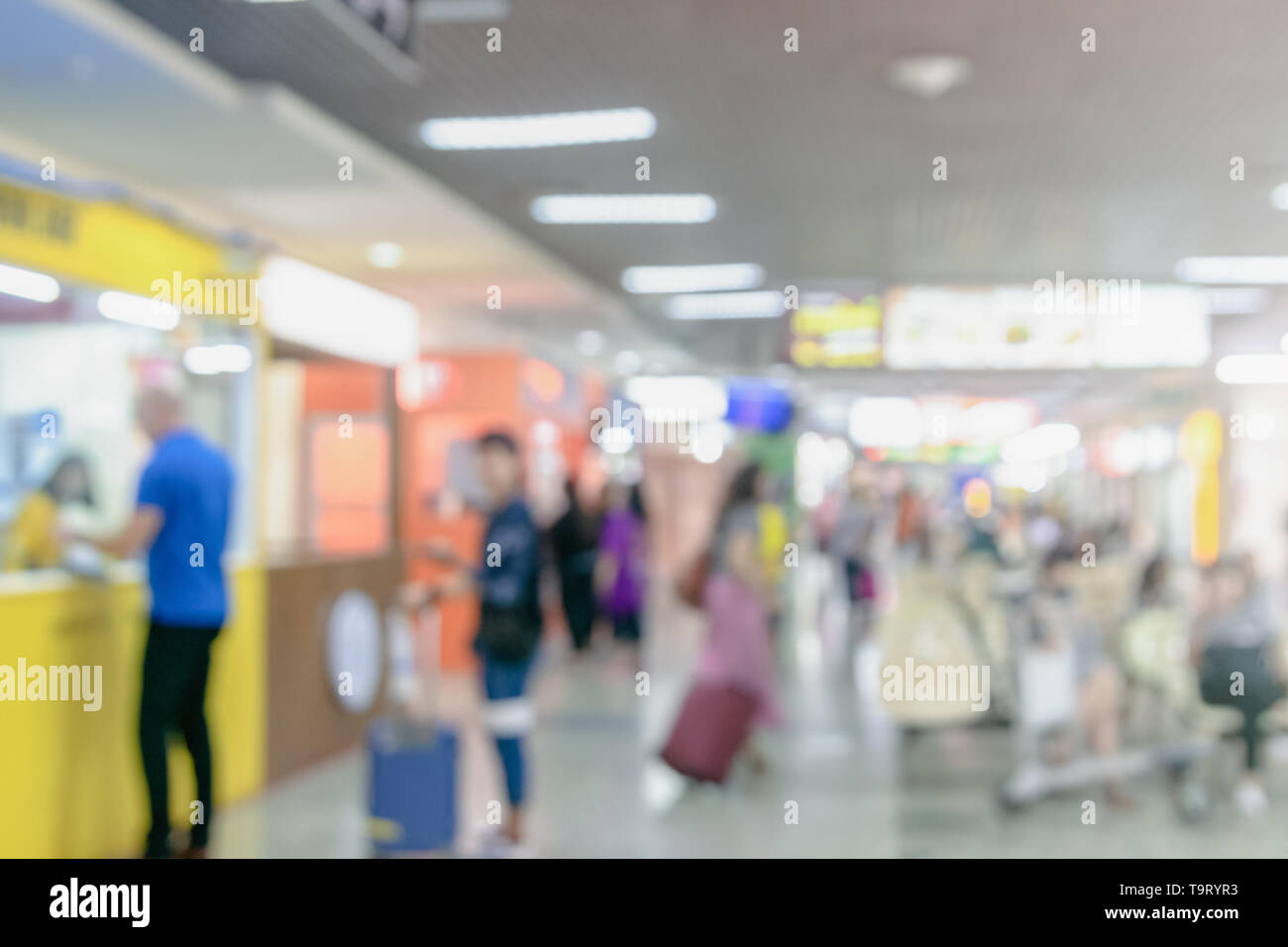 unidentified blurred people check in at airport terminal and sitting for waiting flight travelers walking with a luggage at airport terminal Stock Photo