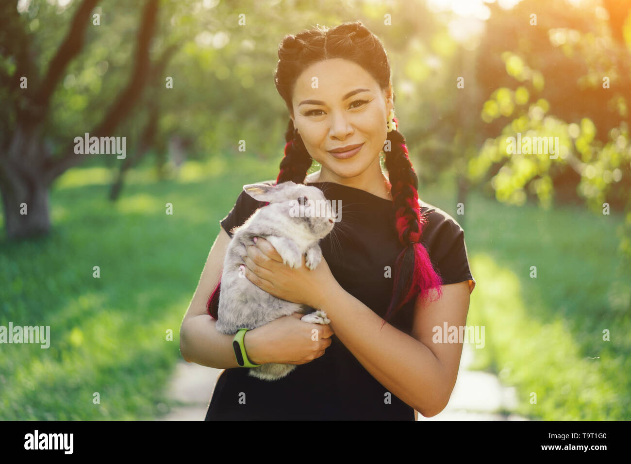 Pretty Asian Girl Hugging Bunny on Summer Nature Stock Photo