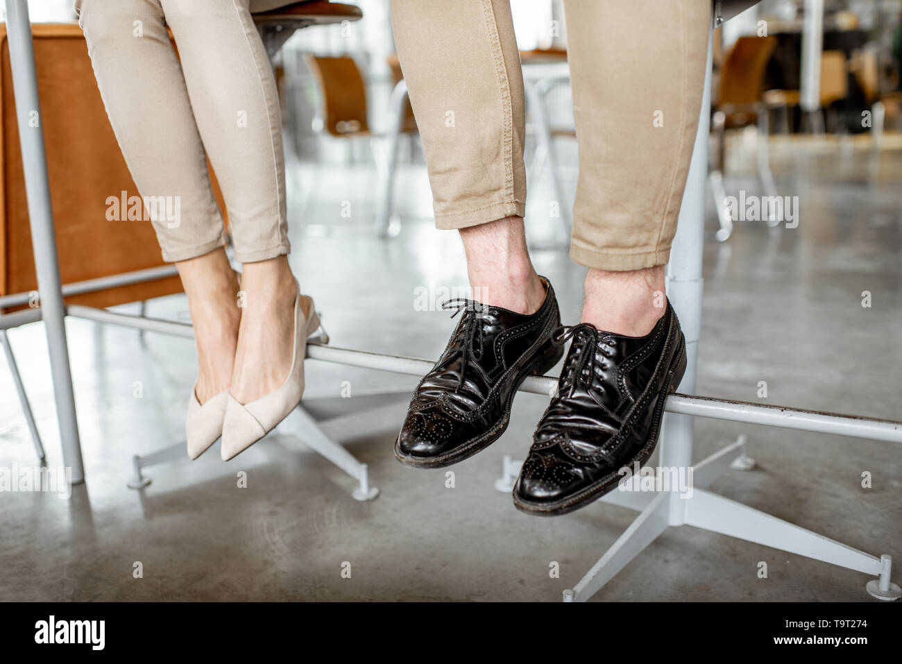Elegant business couple sitting at the bar, view on their legs under the table Stock Photo