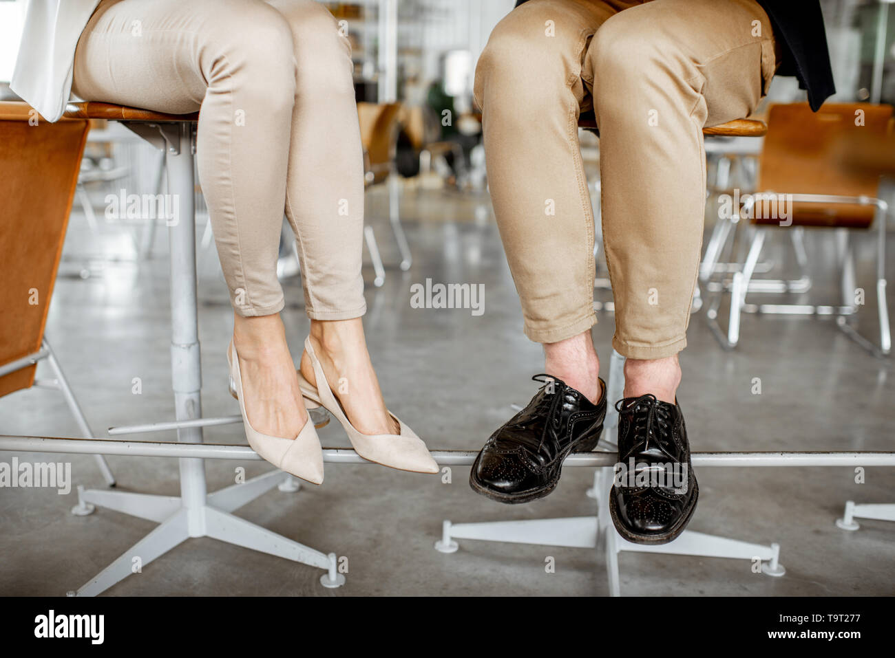 Elegant business couple sitting at the bar, view on their legs under the table Stock Photo