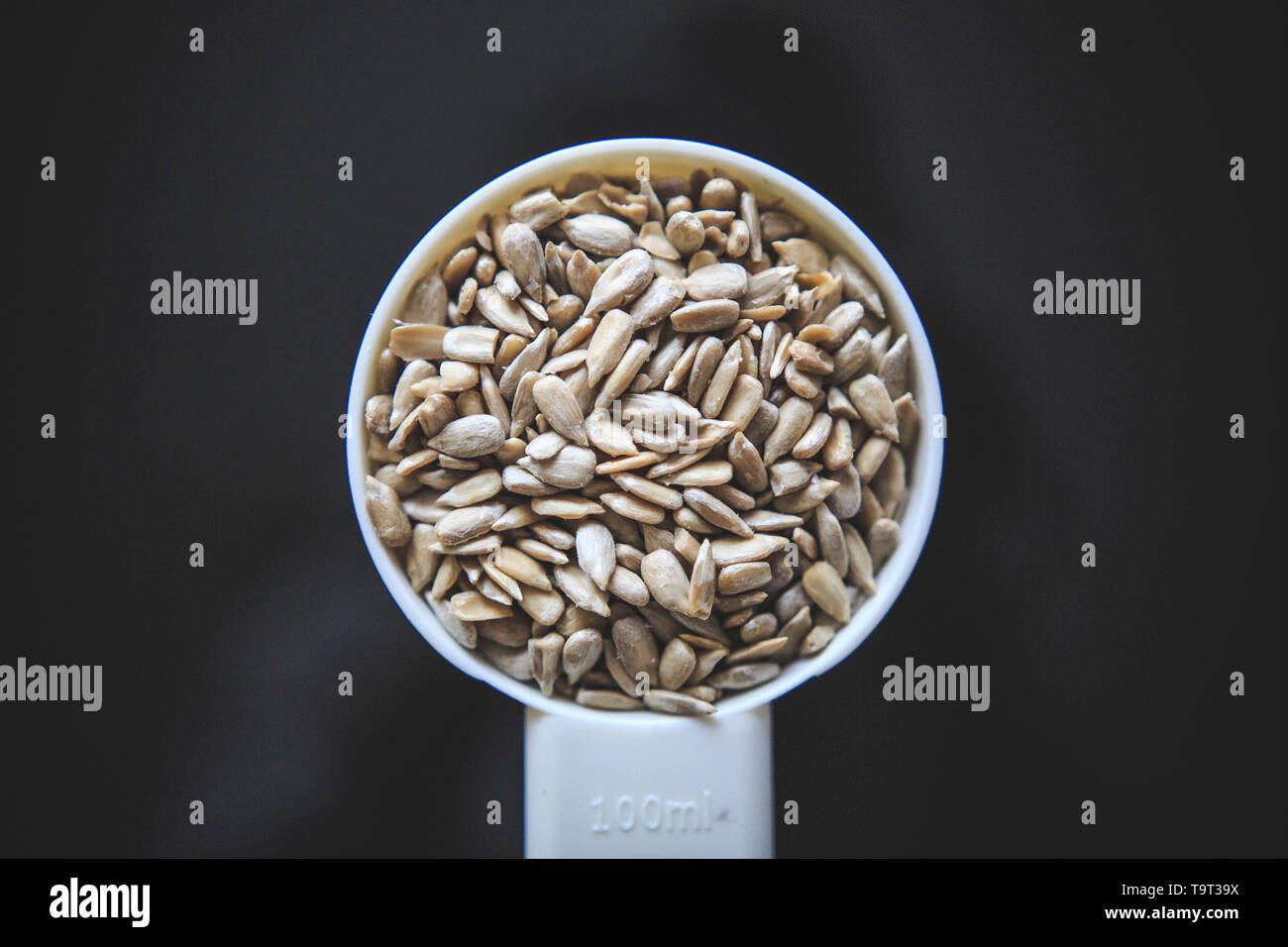 Natural sunflower seeds without shell in the white measuring cup taken