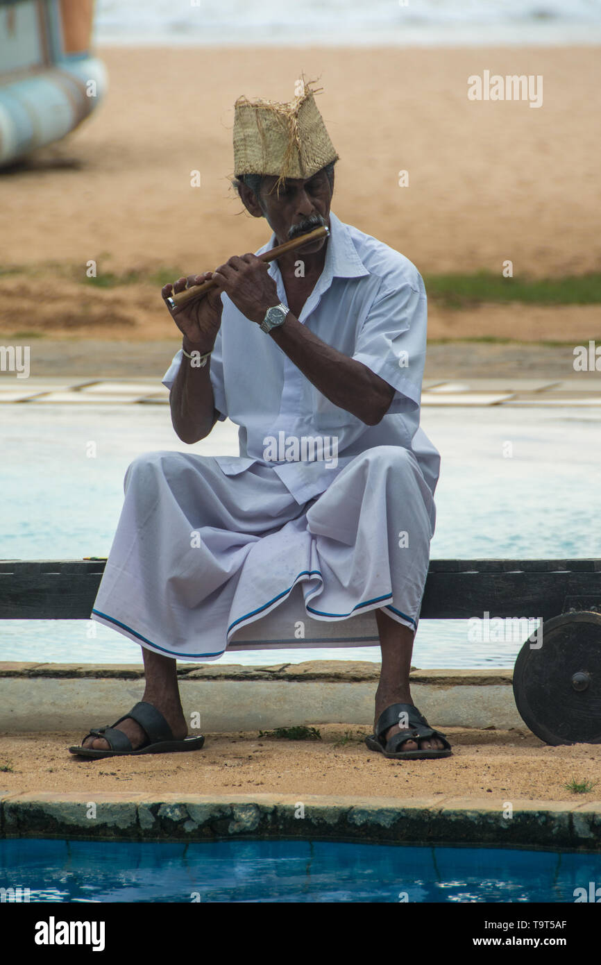 Sri Lanka trip, day 13: the hotel employed a flute player to entertain guests around the pool at the Heritance Ahungalla. Stock Photo