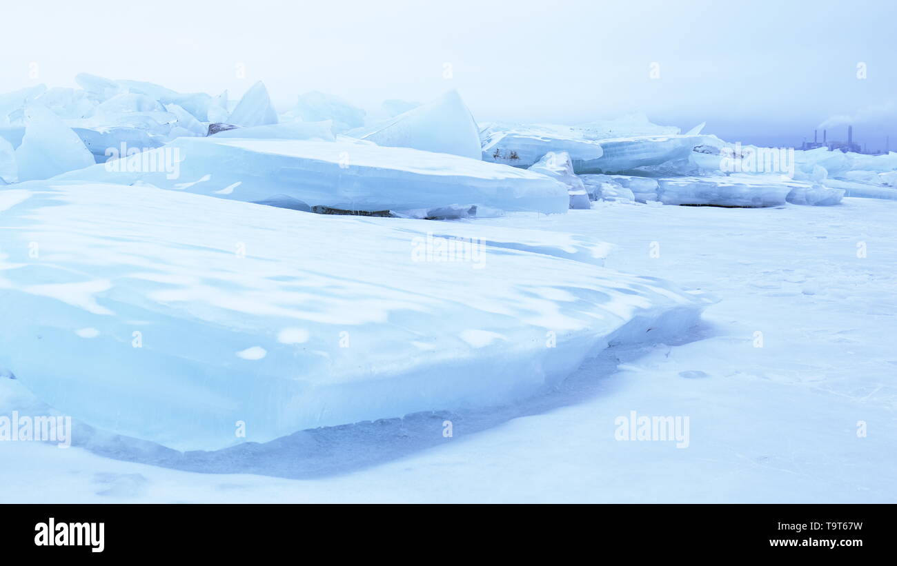 Ice drift with smoke stacks in the background; can be used as a concept illustration of human impact on the environment Stock Photo