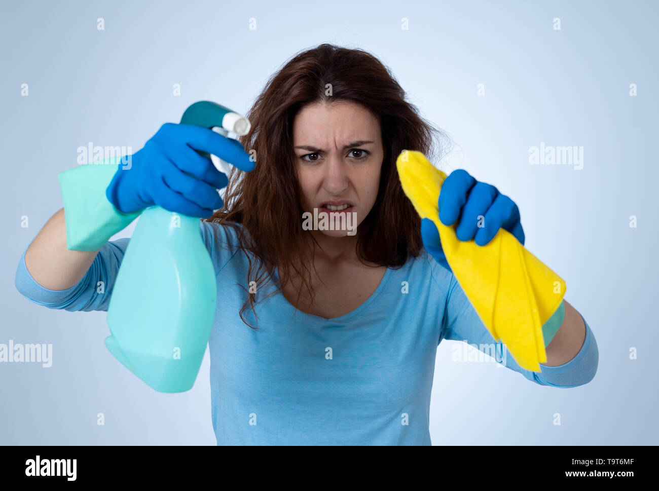 Angry and upset woman with cleaning spray and cloth cleaning feeling ...