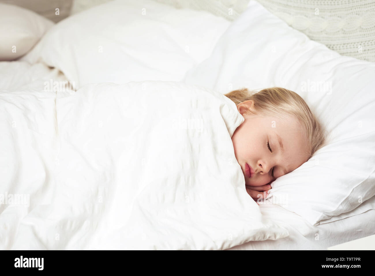 Cute little child girl sleeping in her bed. child wakes up Stock Photo ...