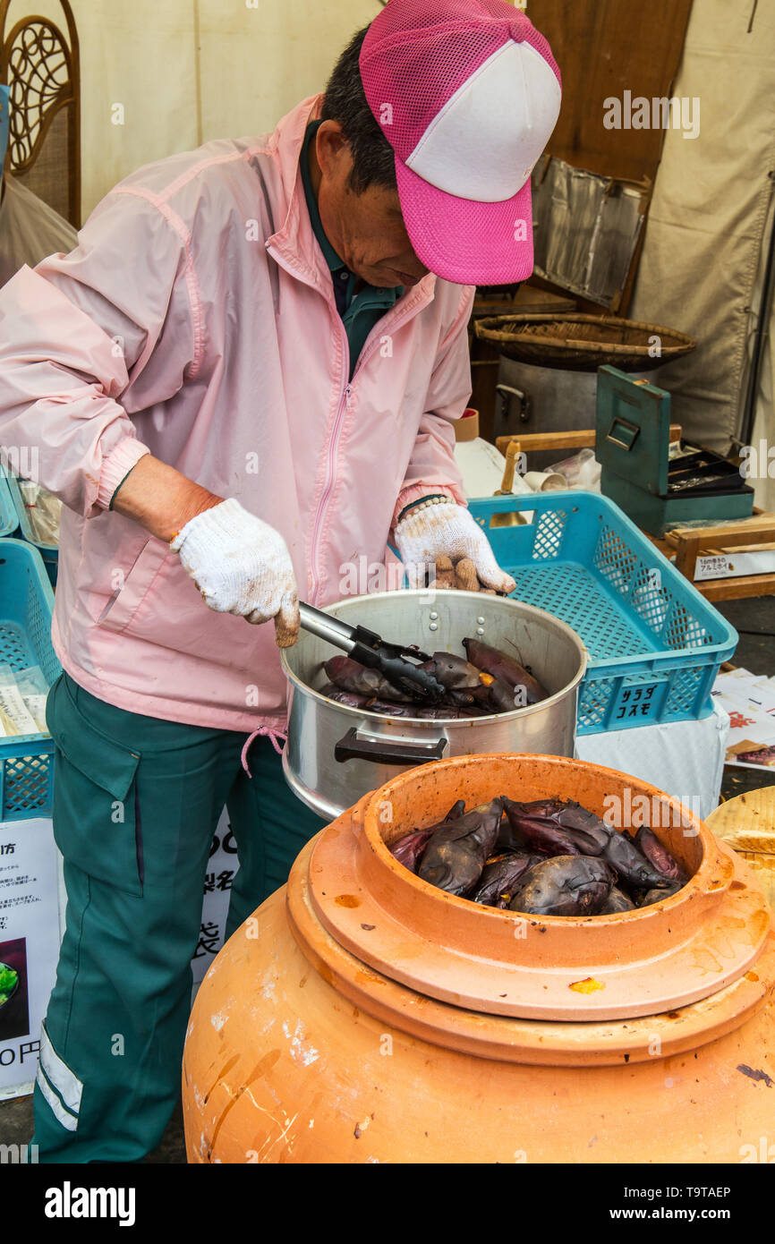 Japanese man preparing food in  japanese amphora, small traditional village Oshino Hakkai. Fuji Five Lake region. Japan. Stock Photo