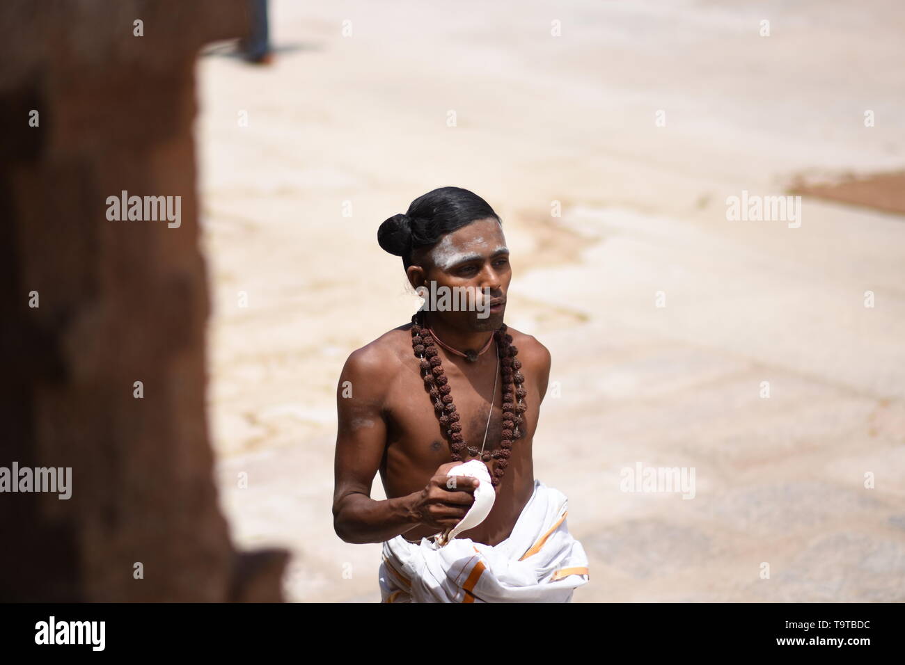 Young Hindu priest with conch shell Stock Photo